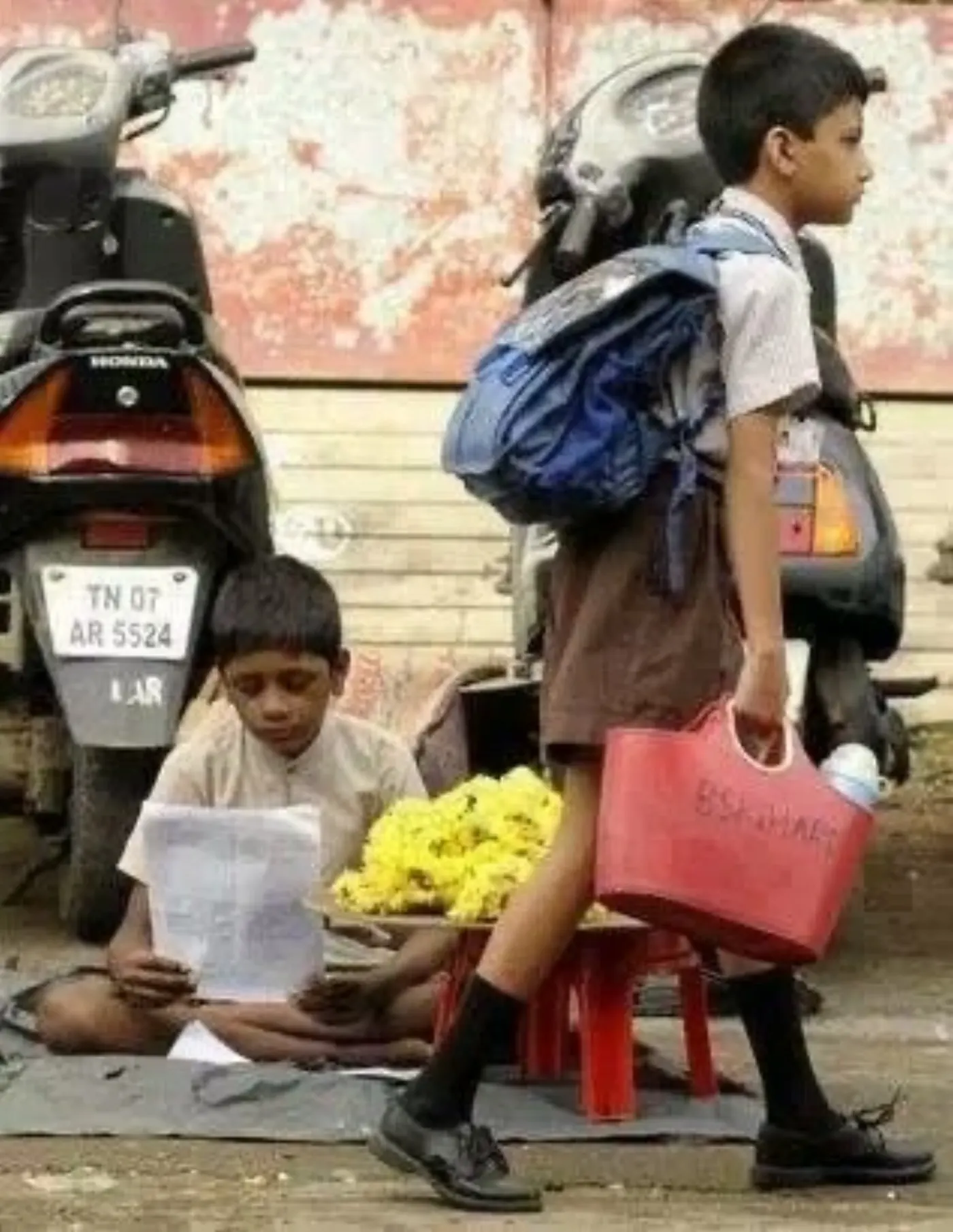 Young student reading his book on a busy street